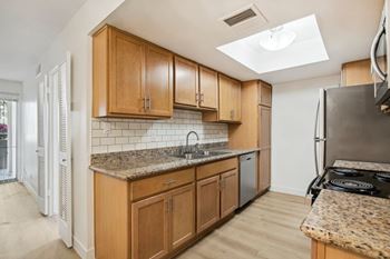 A kitchen with wooden cabinets and a granite countertop. at The Viridian Apartments, Scottsdale, AZ